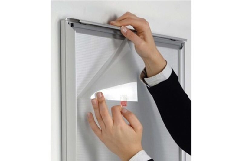 Hands removing protective film from frame.