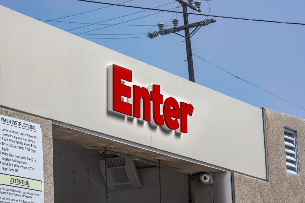 Red "Enter" sign at car wash entrance.